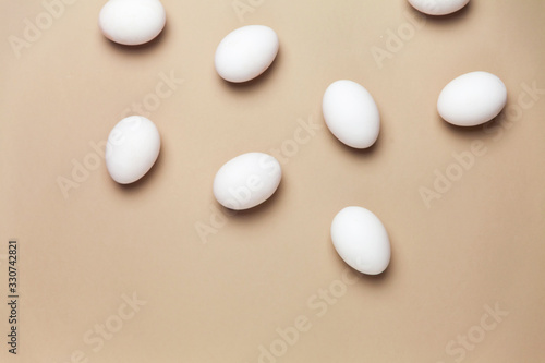 Creative Easter beige and pink background with white eggs. Easter holiday minimal concept.