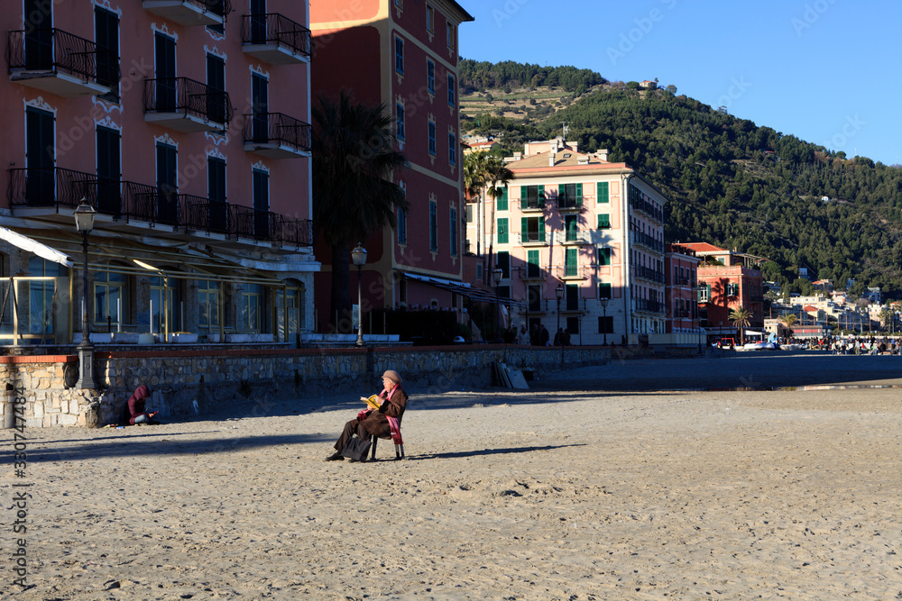 Φωτογραφία Laigueglia (SV), Italy - February 15, 2017: Tourist relaxing at Laigueglia beach, Riviera dei Fiori, Savona, Liguria, Italy