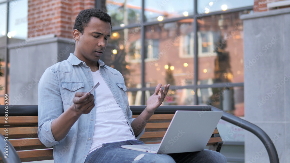 Online Shopping Failure for African Man Sitting on Bench Online Shopping Failure for African Man Sitting on Bench