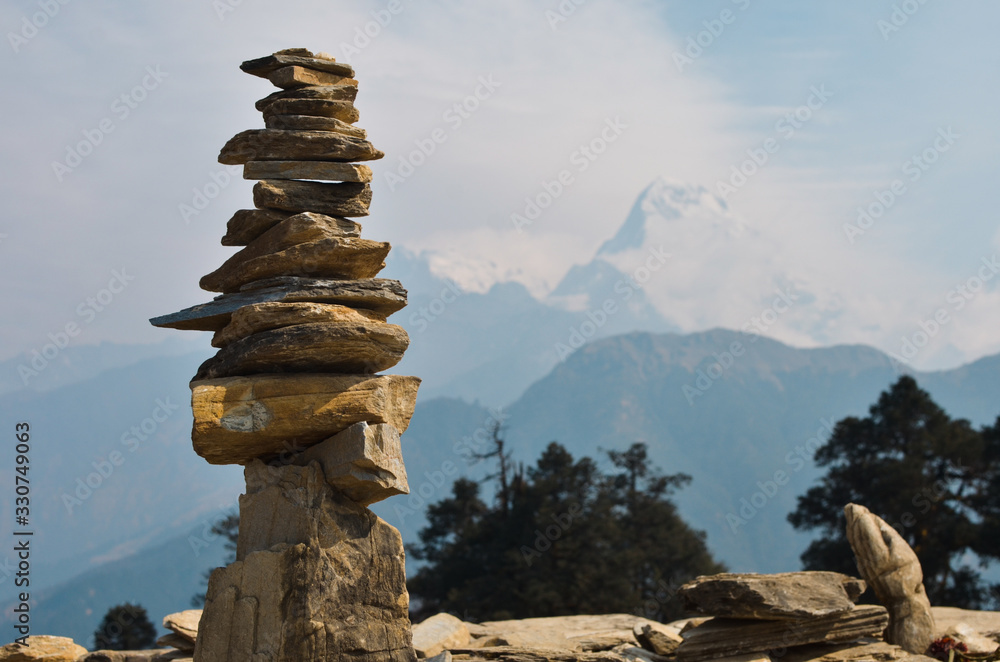 Hito de piedra con montañas nevadas al fondo en el Himalaya Hito de piedra con montañas nevadas al fondo en el Himalaya