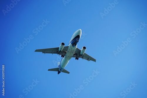 The plane flying in the blue sky. with the clear wiev of the jet. © U