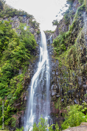 Long exposure of the Risco waterfall on madeira island, portugal, in the middle of the tropical forest