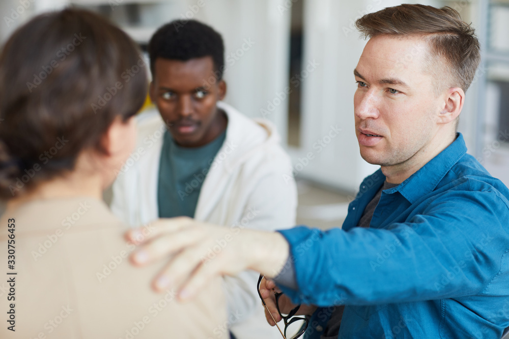 Obraz premium Portrait of adult man comforting woman in psychology support group, copy space