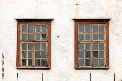 Wall of a residential building with closed windows and old stucco House Exterior Details in Estonia