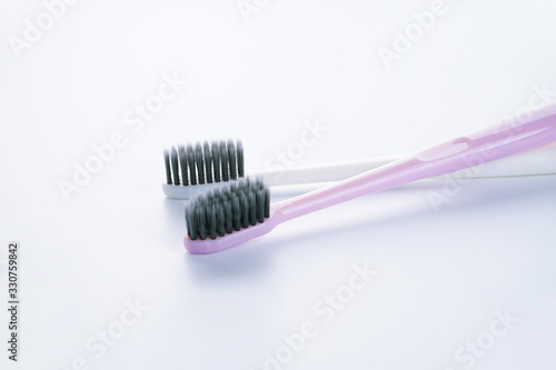 Two beautiful multi-colored toothbrushes with black shields  on a white background. Close-up. Is isolated.