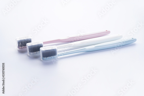 Multi-colored toothbrushes with black bristles on a white background.