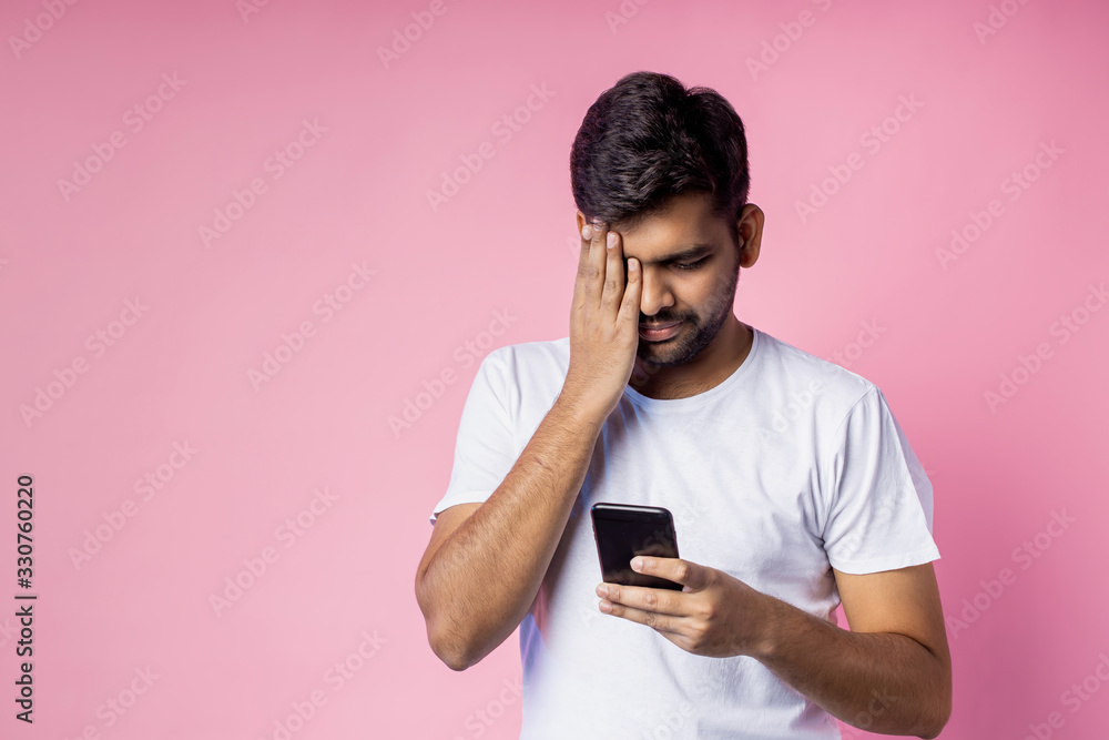 Portrait of handsome Indian guy standing on pink background Portrait of handsome Indian guy standing on pink background