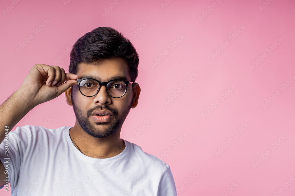 Portrait of handsome Indian guy standing on pink background Portrait of handsome Indian guy standing on pink background
