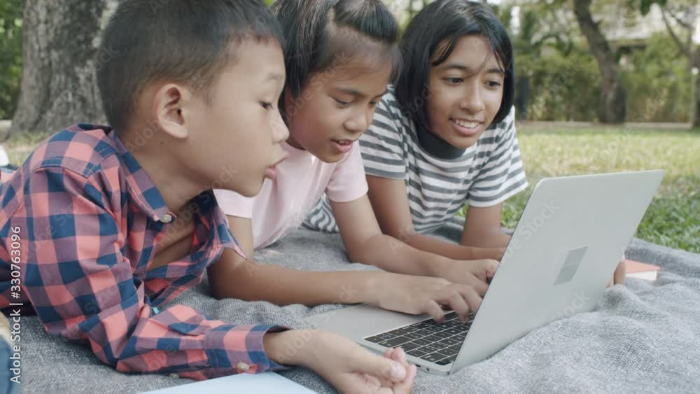 Group of Asian student school working together with laptop at the park Group of Asian student school working together with laptop at the park