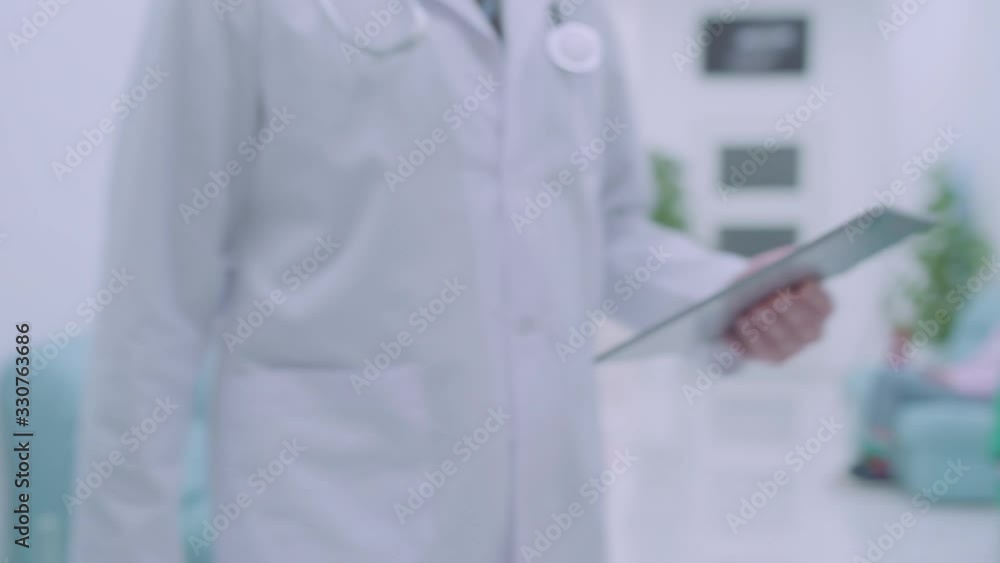 Male doctor with tablet shaking hand of female colleague in hospital, team work Male doctor with tablet shaking hand of female colleague in hospital, team work
