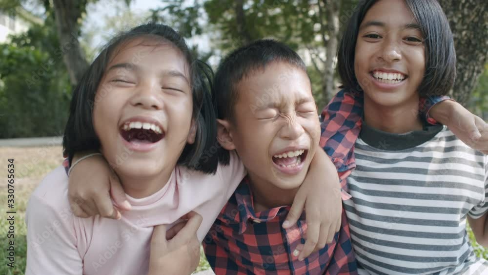 group of Asian children are hug their neck and laughing happy in park. 