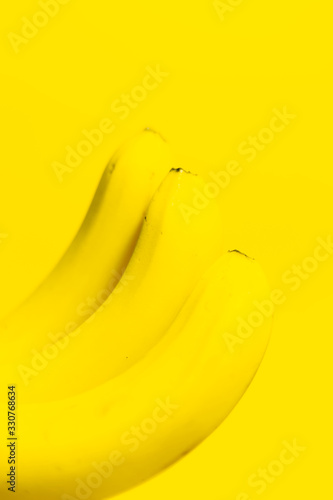 Close-up of three bananas on background of yellow color.