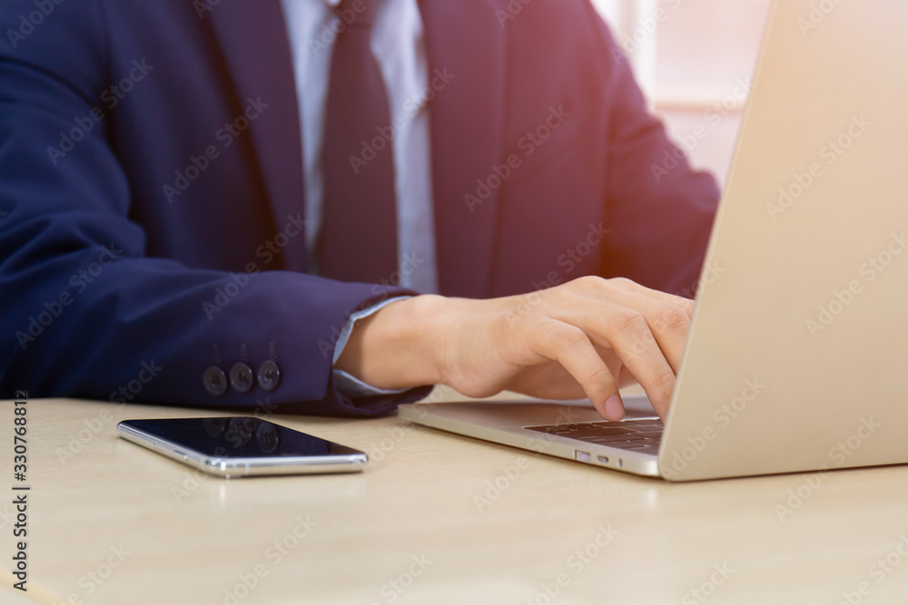 A man with a business man typing on a desk with a laptop A man with a business man typing on a desk with a laptop