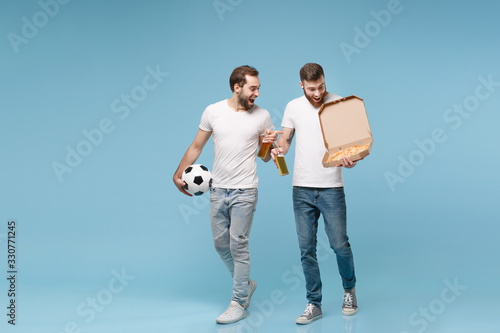 Excited men guys friends in white t-shirt isolated on pastel blue background. Sport leisure concept. Cheer up support favorite team with soccer ball, beer bottle, italian pizza in cardboard flatbox.