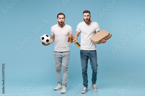 Shocked men guys friends in white t-shirt isolated on pastel blue background. Sport leisure concept. Cheer up support favorite team with soccer ball, beer bottle, italian pizza in cardboard flatbox.
