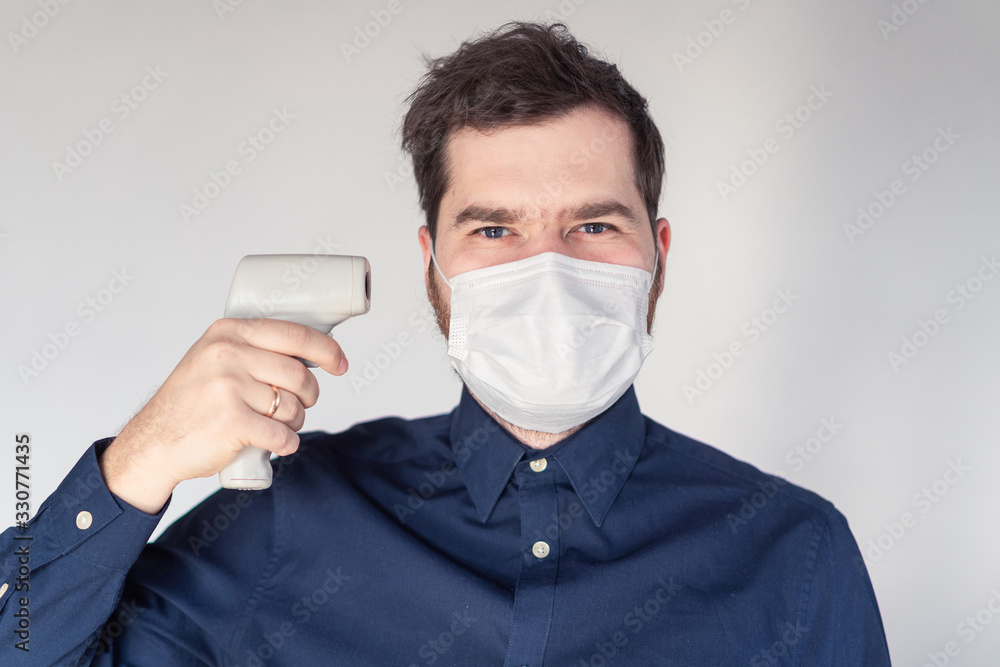 Men during epidemic in medical mask with body thermometer Men during epidemic in medical mask with body thermometer