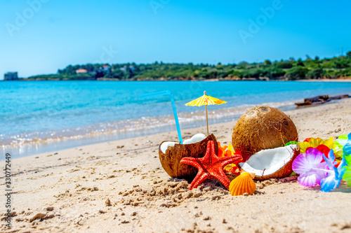 Fototapeta Naklejka Na Ścianę i Meble -  Coconut cocktail, starfish and shells on the beach
