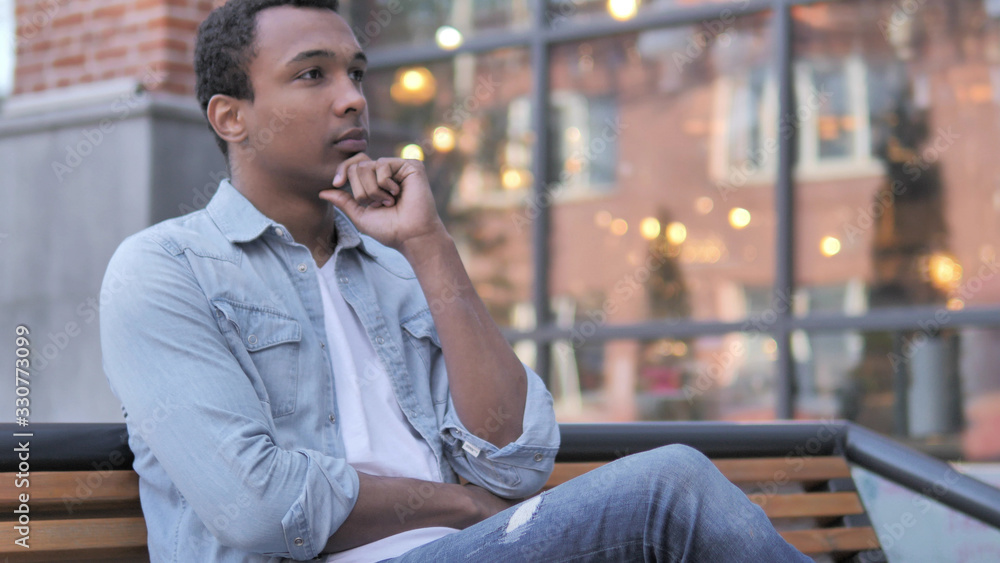 Fotografie Thinking African Man Sitting Outdoor