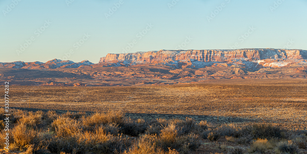 Panorama image of the morning light striking the cliffs of Vermilion Cliffs National Monument outside of Page, Arizona.