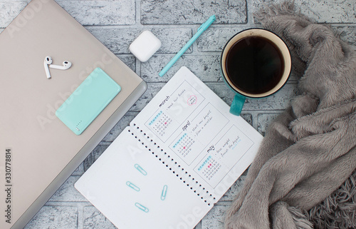 Concept layout of work place. Notebook, planner and a cup of coffee on a stone background