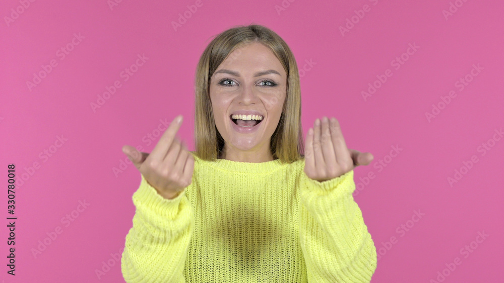 Cheerful Young Girl Pointing Finger and Inviting, Pink Background Cheerful Young Girl Pointing Finger and Inviting, Pink Background