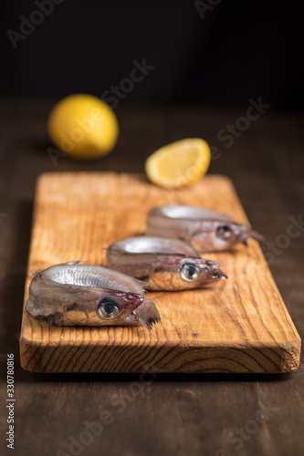 Blue whiting or lilies, fish on the table prepared to be cleaned and cooked in different ways, battered, baked, pickled. Tasty and healthy seasonal white fish.