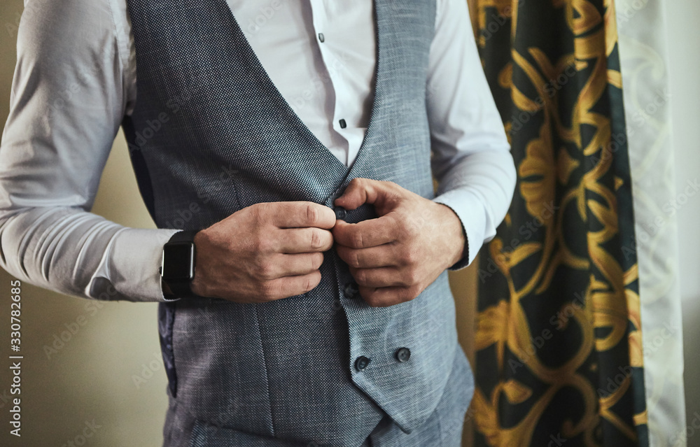 Businessman wears a jacket,male hands closeup,groom getting ready in the morning before wedding ceremony