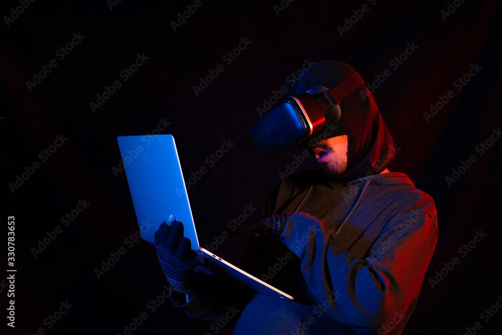 Masked robbers on a black background are using modern technology tools. Masked robbers on a black background are using modern technology tools.