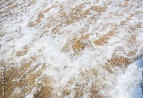 White light seafoam waves on the golden sand beach.