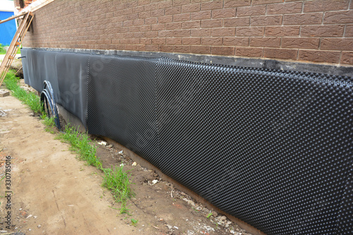 Foto Exterior waterproofing of building foundation with a waterproofing membrane and soil side drainage membrane