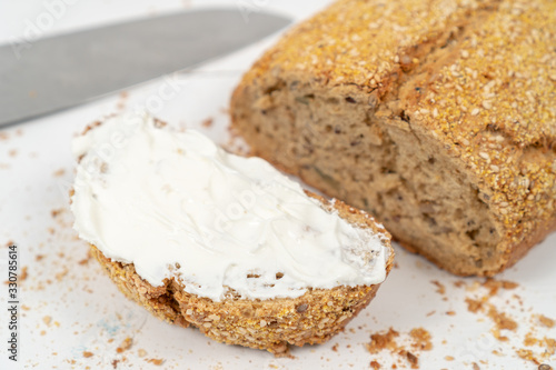 Sliced Bread With Sesame Seeds And Sour Cream On The White Wooden Boards