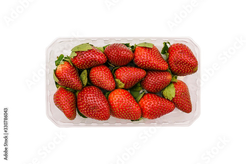 Plastic container with strawberries isolated on a white background. Fresh and ripe summer berries in the package. Top view, flat lay. photo