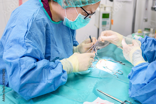 Female surgeon in operation room, operating a patient .