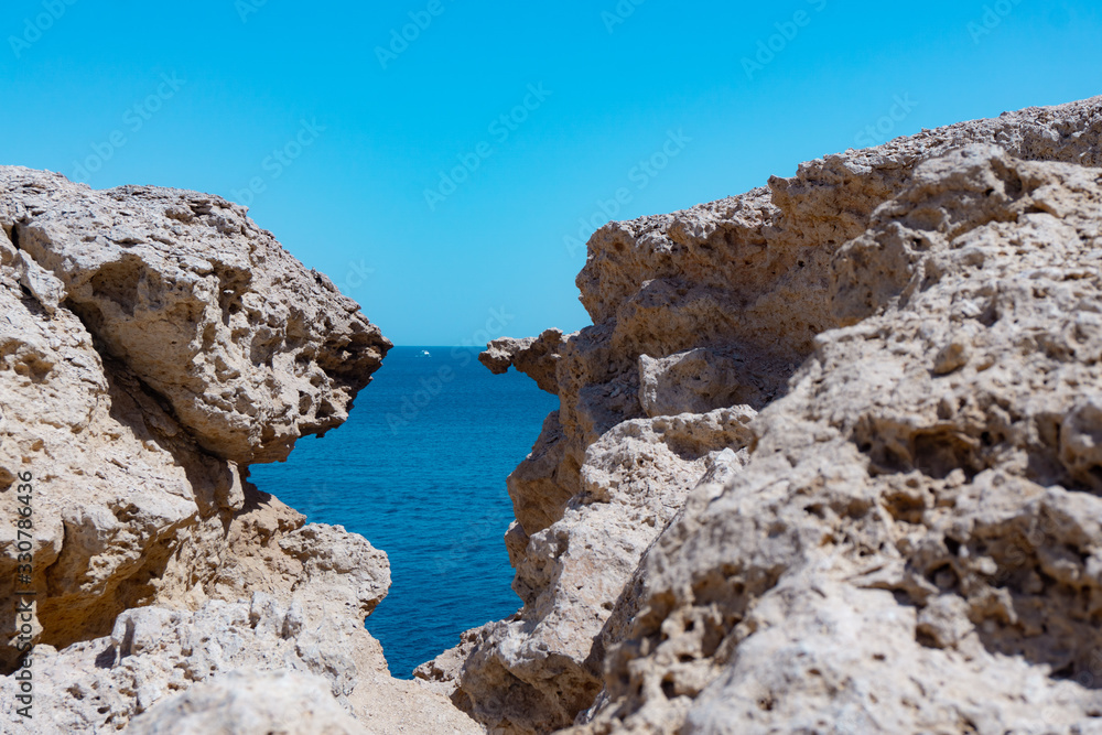 Rock crevass with a seashell overlooking the sea and sky. Sunny day in warm Egypt and the Red Sea