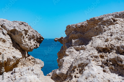 Rock crevass with a seashell overlooking the sea and sky. Sunny day in warm Egypt and the Red Sea