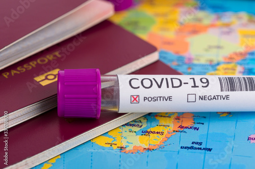 Coronavirus and travel concept. Epidemic in Wuhan, China. World map showing countries with COVID-19 cases. Blood sample in a tube, world map, passport and mask. Travel restrictions and quarantine