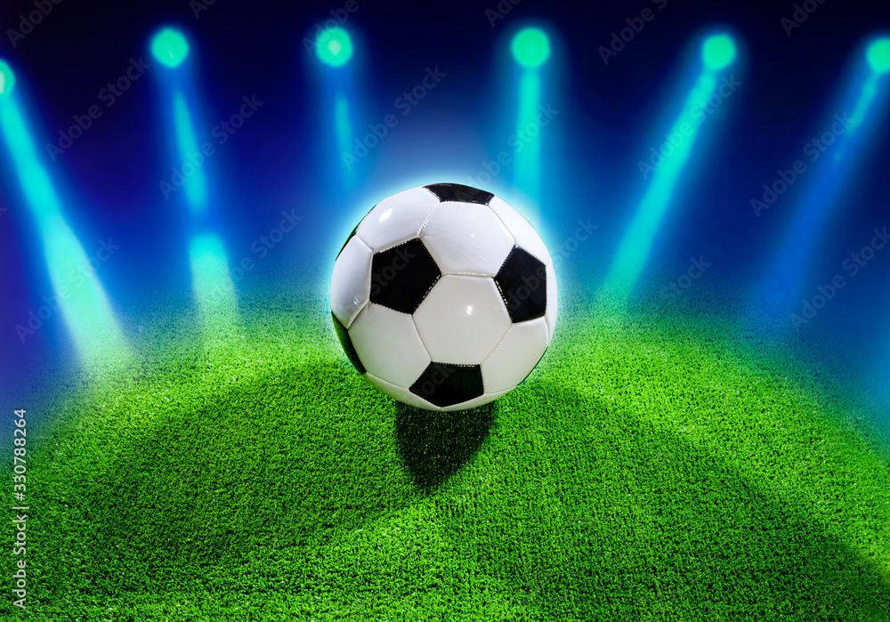 Classic black and white soccer ball illuminated in a stadium