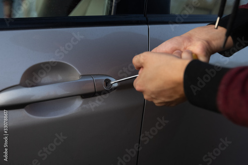 A man is trying to break the car lock.