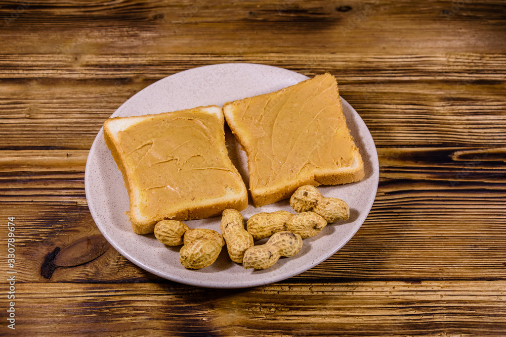 Fototapeta premium Sandwiches with peanut butter in plate on a wooden table