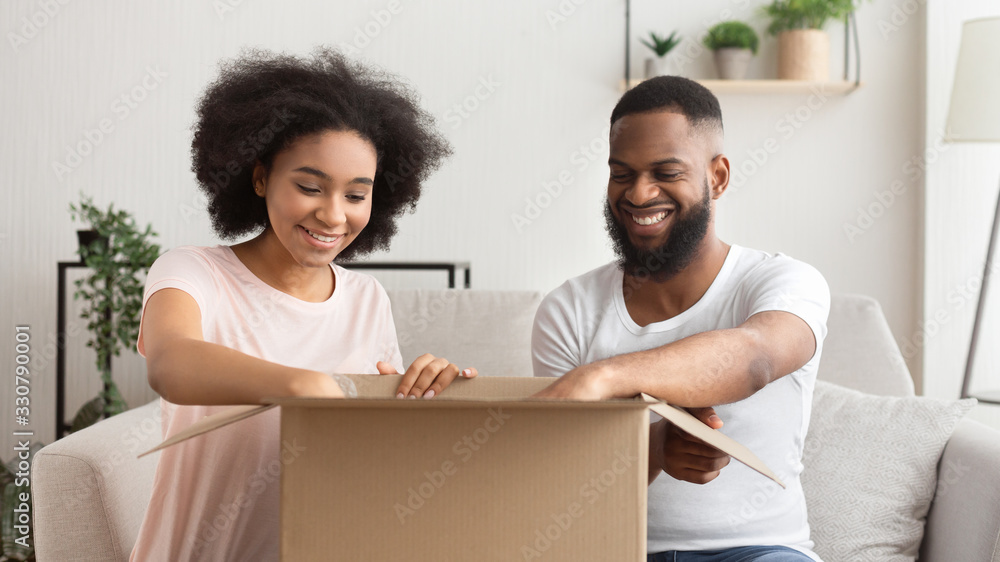 African american couple opens box from online store African american couple opens box from online store