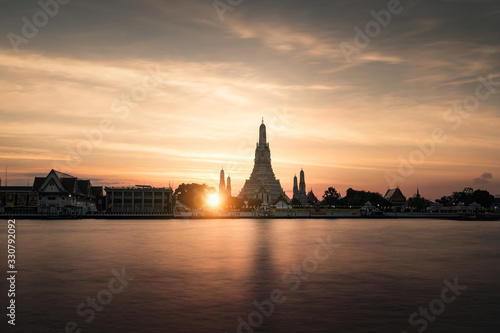 Wat arun temple, bangkok, thailand, during sunset with reflects on the water 