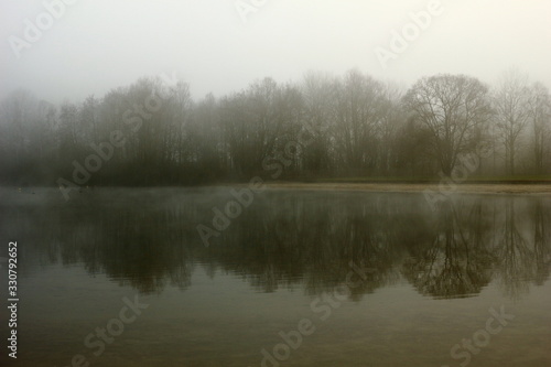 Foggy, wintery images of a lake: the Plas in Rotselaar in Flanders, Belgium. De Plas is an artificial lake created by sand extraction. Swimming and windsurfing in the summer.