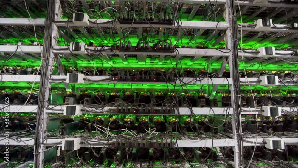 Cryptocurrency mining equipment on large farm. ASIC miners on stand racks mine bitcoin in server room. Blockchain techology application specific integrated circuit. Tripod tilt. Cryptocurrency mining equipment on large farm. ASIC miners on stand racks mine bitcoin in server room. Blockchain techology application specific integrated circuit. Tripod tilt.