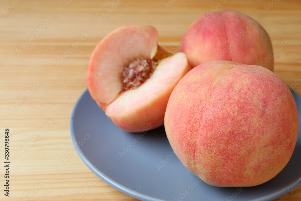 Closeup Fresh Ripe Peaches on Blue Plate with Blurry Cut Peach in the Backdrop Closeup Fresh Ripe Peaches on Blue Plate with Blurry Cut Peach in the Backdrop