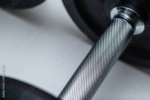 Close-up of adjustable dumbbell handle with attached weights on white background. Concept of training, fittness and excercise for a healthy living.
