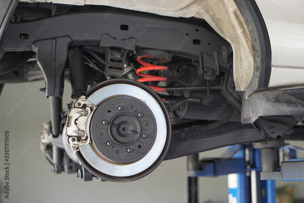 Disc brake of the vehicle for repair, in process of new tire replacement. Car brake repairing in garage.Selective focus disc brake on car, in process of new tire replacement.Close up. Disc brake of the vehicle for repair, in process of new tire replacement. Car brake repairing in garage.Selective focus disc brake on car, in process of new tire replacement.Close up.