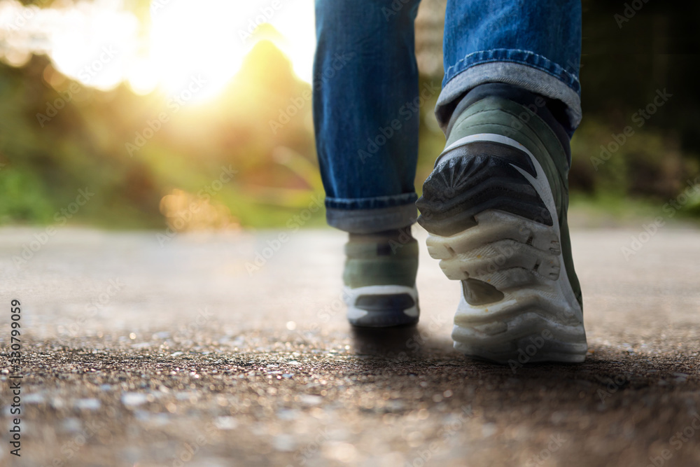 Life and Challenging Concept. Low Section of Motivated Young Man Walking in Outdoor. Natural Sunlight as background Life and Challenging Concept. Low Section of Motivated Young Man Walking in Outdoor. Natural Sunlight as background
