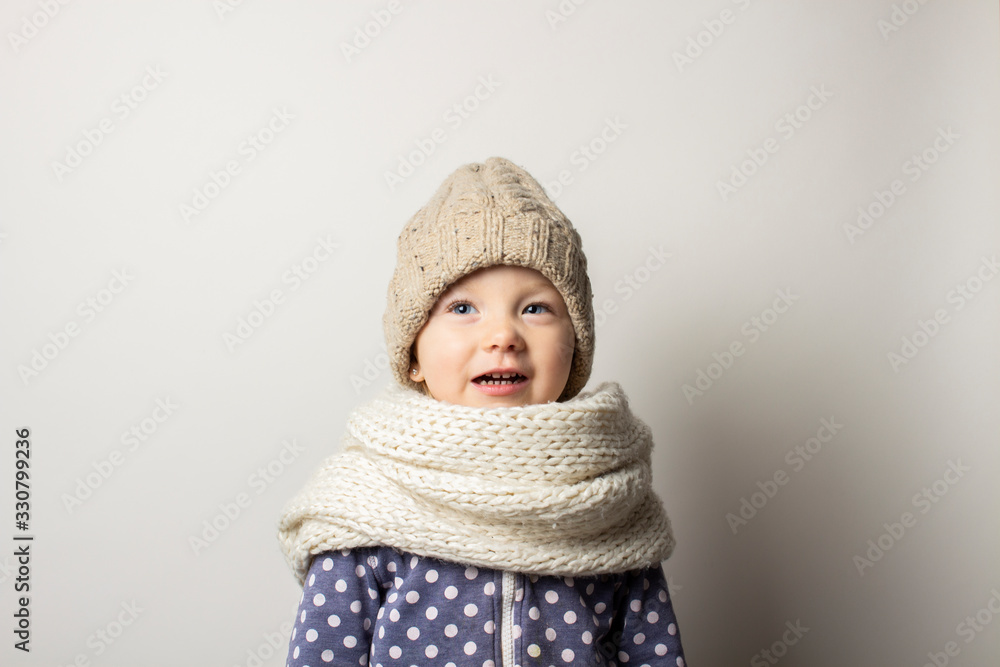 beautiful little baby in a hat on a light background. Concept of children's emotions, winter, shopping beautiful little baby in a hat on a light background. Concept of children's emotions, winter, shopping