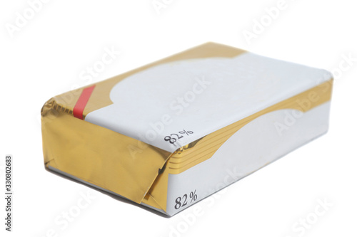 Stick of wrapped butter isolated on white background