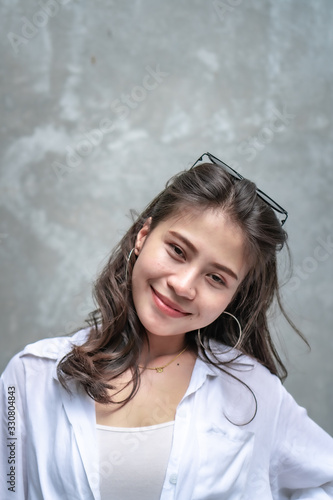 Asian beautiful woman with yellow skin, long black hair, wearing a white shirt, jeans showing her emotions.  Cement wall background-01